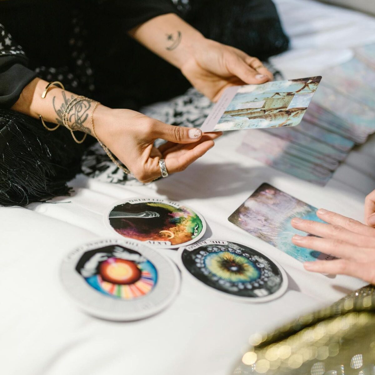 Two people engaging in a tarot card reading session with colorful cards and spiritual symbols.
